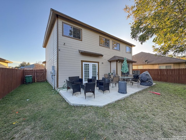 back of house with a lawn, a patio area, and french doors