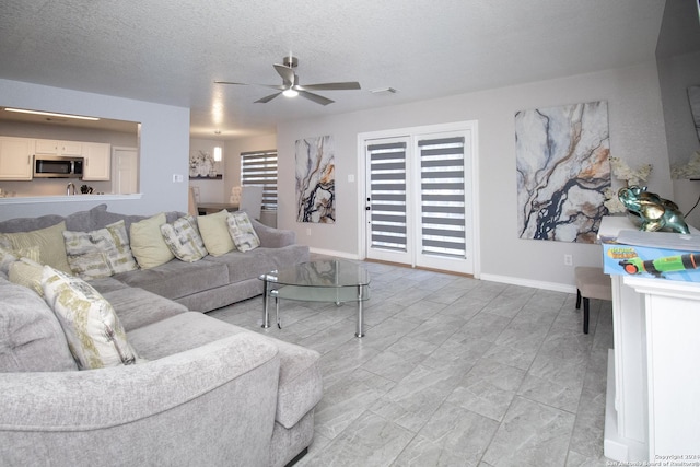 living room featuring a textured ceiling and ceiling fan