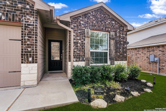 doorway to property with stone siding and brick siding