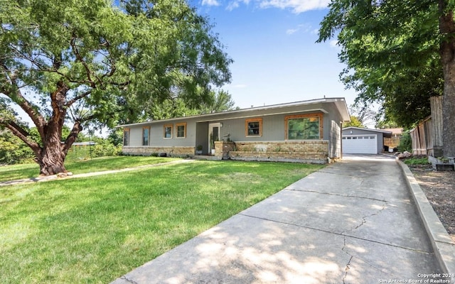 single story home featuring a garage, an outbuilding, and a front lawn