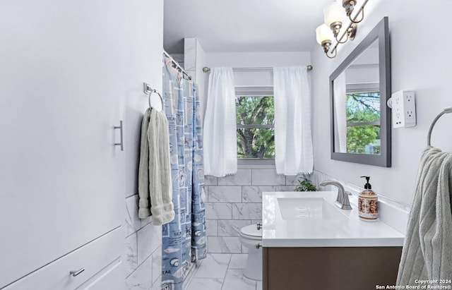 bathroom featuring vanity, tile walls, and toilet