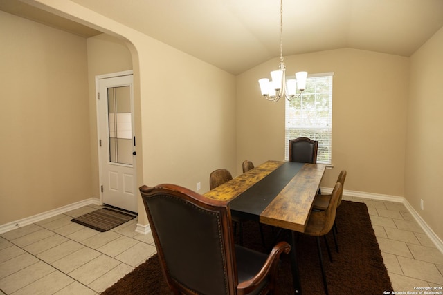 tiled dining space featuring a chandelier and vaulted ceiling