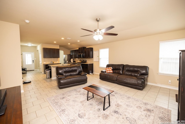 tiled living room featuring ceiling fan and vaulted ceiling