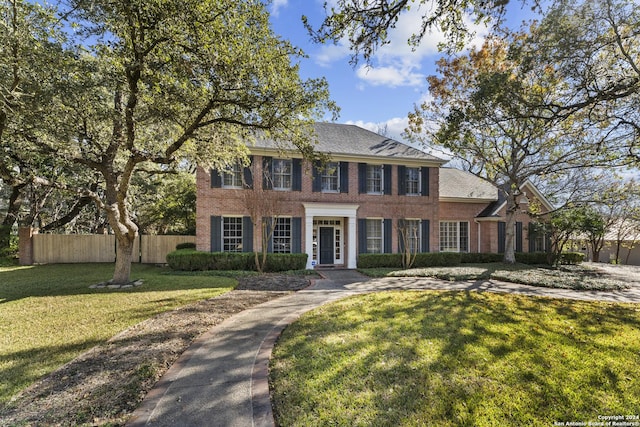 colonial inspired home featuring a front lawn