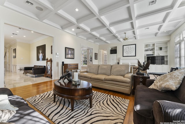 living room featuring beam ceiling, ceiling fan, coffered ceiling, built in features, and light hardwood / wood-style flooring