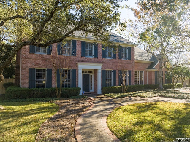 colonial home featuring a front lawn