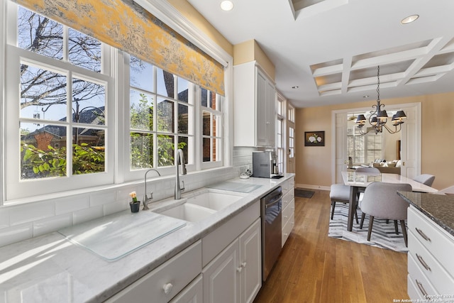 kitchen with beam ceiling, light stone counters, white cabinets, and coffered ceiling