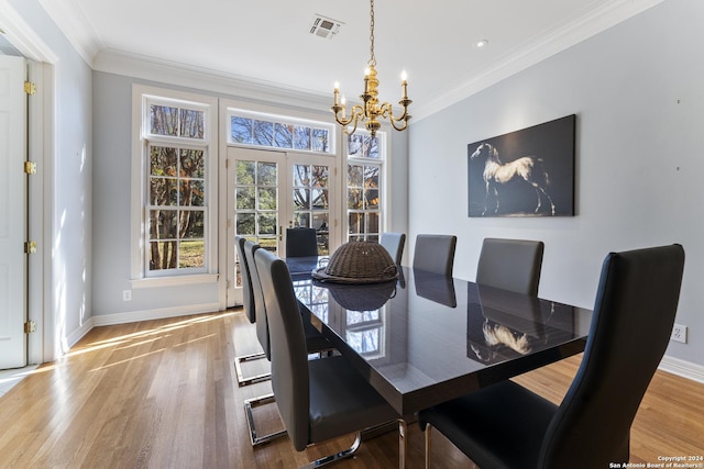 dining area featuring hardwood / wood-style floors, ornamental molding, and an inviting chandelier