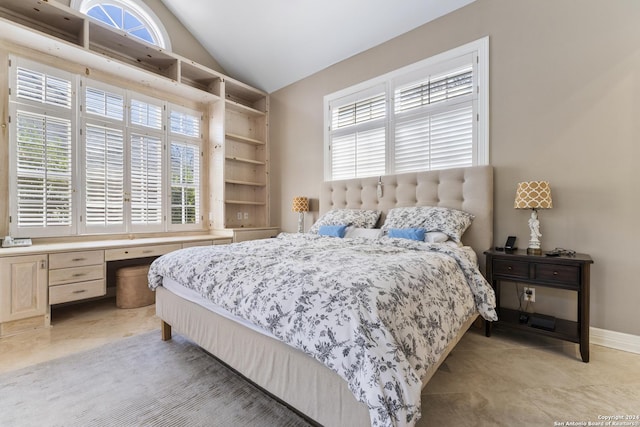 bedroom with high vaulted ceiling and built in desk