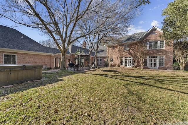 view of yard featuring french doors and a hot tub