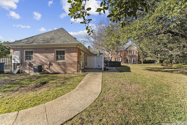 view of property exterior with a yard and central air condition unit