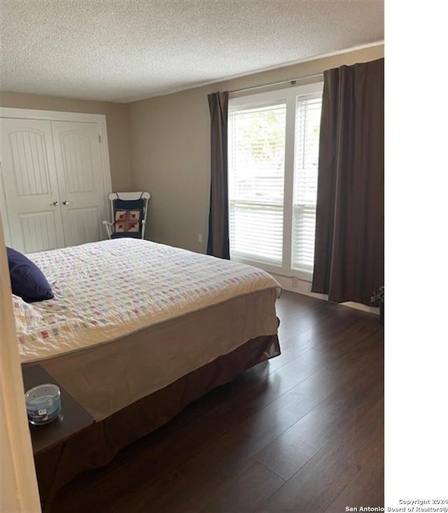 bedroom featuring a textured ceiling, a closet, and dark wood-type flooring