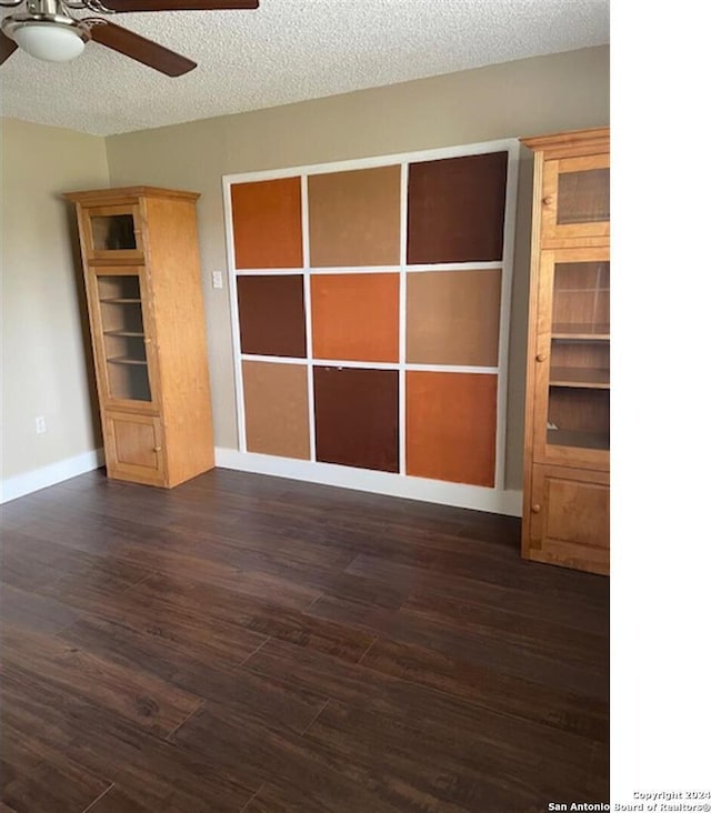 spare room with ceiling fan, dark hardwood / wood-style floors, and a textured ceiling