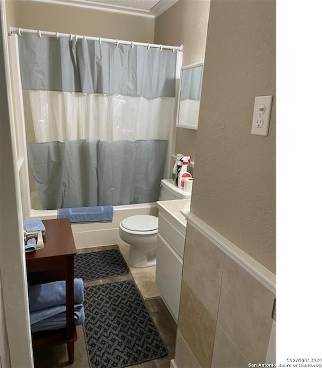 full bathroom with vanity, toilet, ornamental molding, a textured ceiling, and shower / tub combo