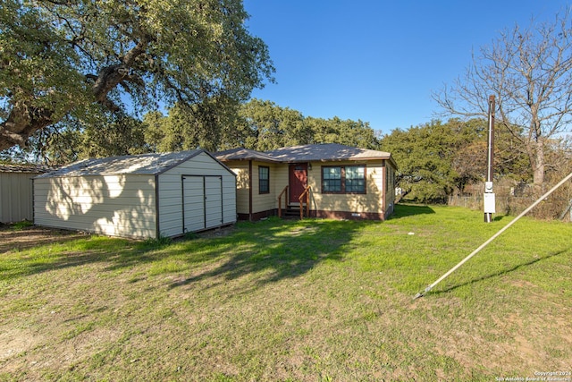 back of house with a lawn and a shed