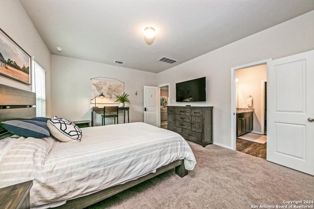 bedroom with carpet flooring and connected bathroom