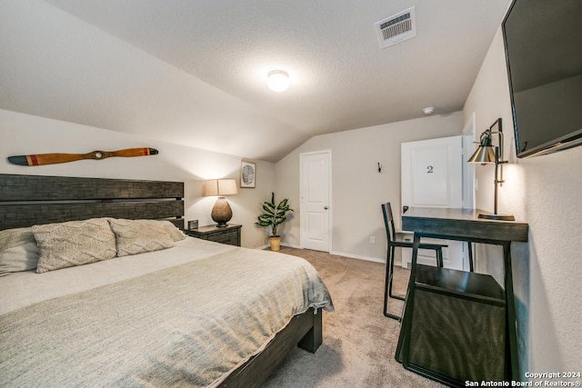 carpeted bedroom featuring a textured ceiling and vaulted ceiling