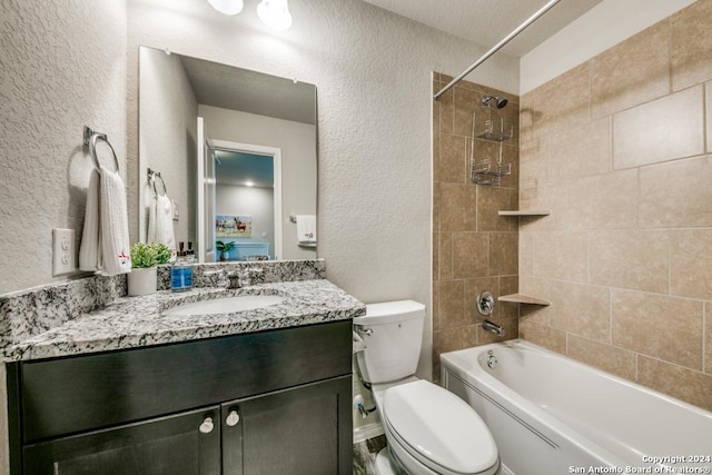 full bathroom featuring tiled shower / bath combo, toilet, and vanity