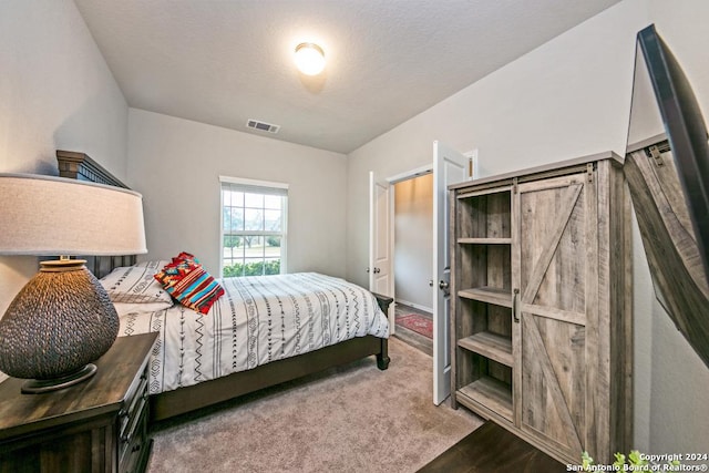 carpeted bedroom with a textured ceiling