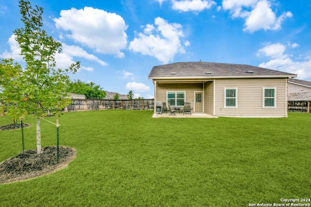 rear view of property featuring a patio and a lawn