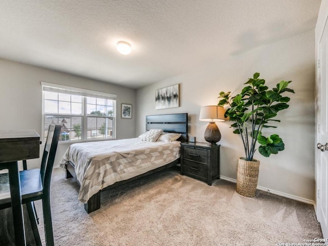 bedroom featuring light carpet and a textured ceiling