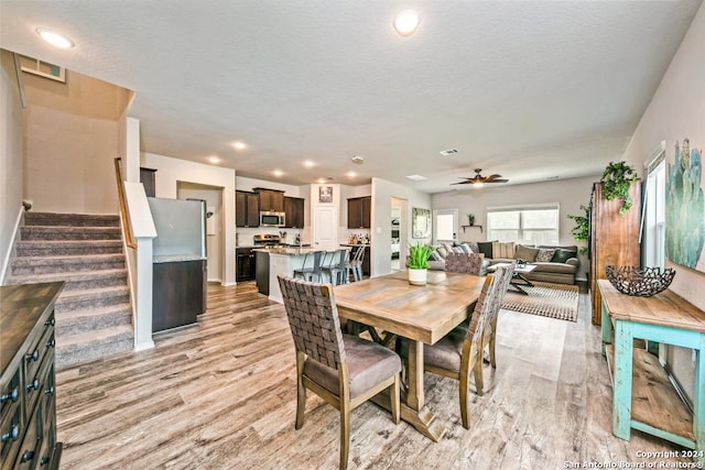 dining space with a textured ceiling, light hardwood / wood-style flooring, and ceiling fan