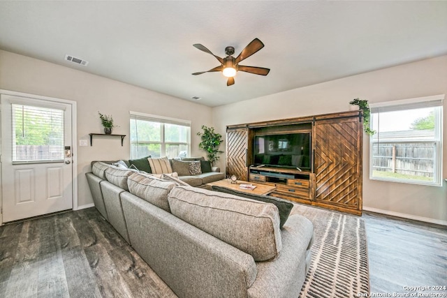 living room with ceiling fan and dark wood-type flooring