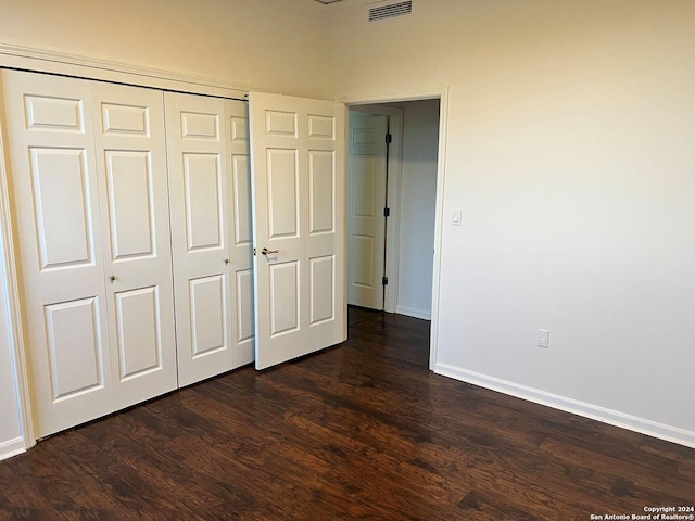 unfurnished bedroom featuring dark wood-type flooring and a closet