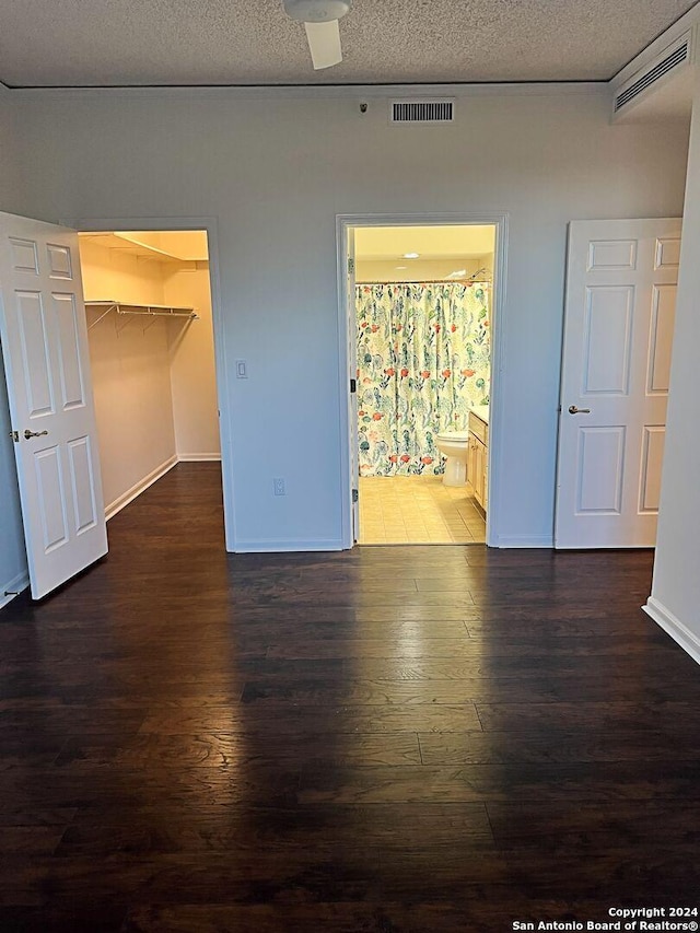 empty room featuring a textured ceiling and dark hardwood / wood-style flooring