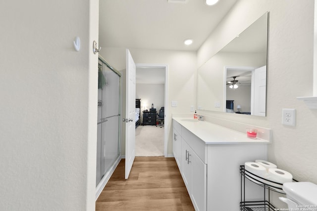 bathroom featuring wood-type flooring, vanity, ceiling fan, and a shower with shower door