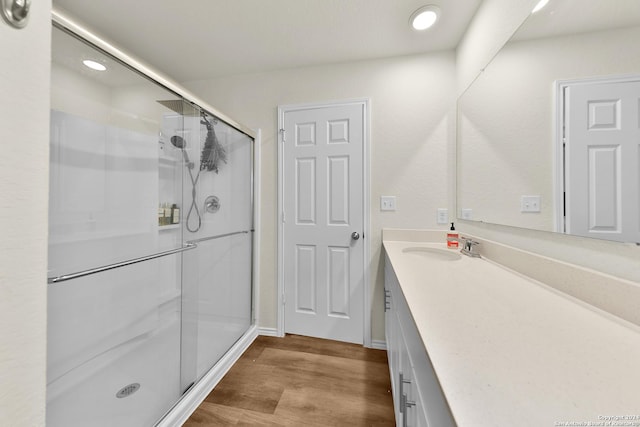 bathroom featuring hardwood / wood-style floors, vanity, and walk in shower