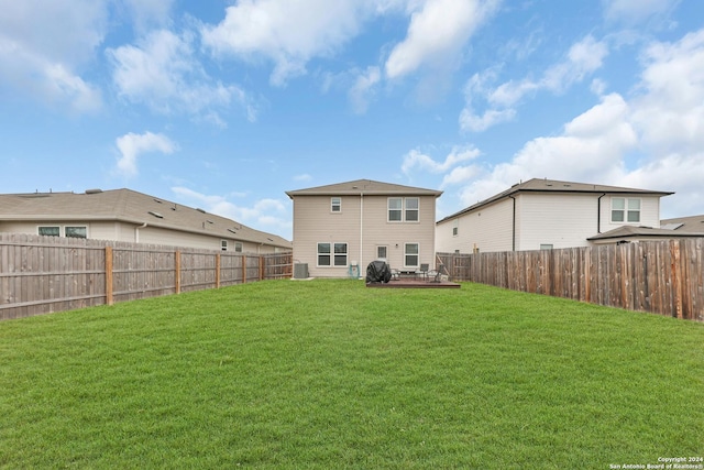 rear view of property with a lawn and central AC