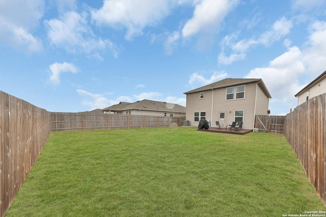 view of yard with central AC and a deck