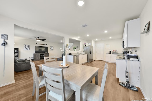 dining area with ceiling fan and light hardwood / wood-style flooring