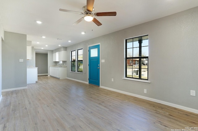 unfurnished living room featuring ceiling fan and light hardwood / wood-style flooring