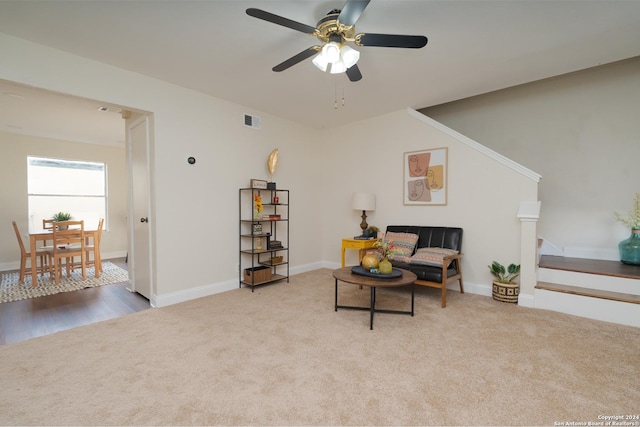 carpeted living room with ceiling fan