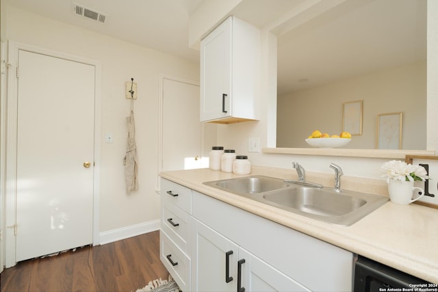 kitchen with white cabinets, dark hardwood / wood-style flooring, dishwashing machine, and sink