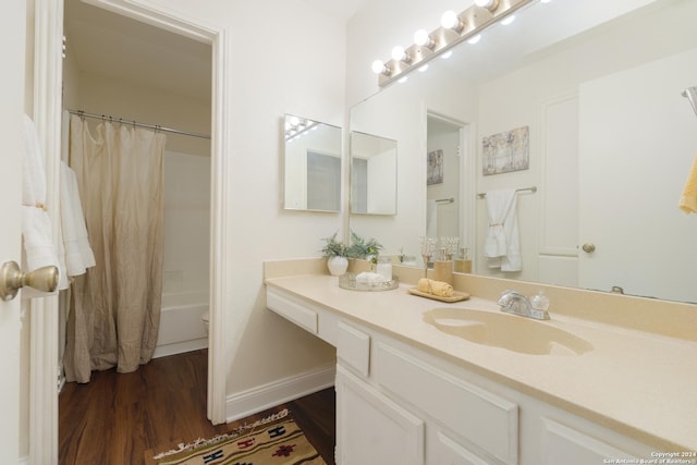 full bathroom featuring hardwood / wood-style floors, vanity, toilet, and shower / tub combo