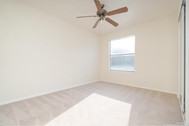 carpeted spare room featuring ceiling fan