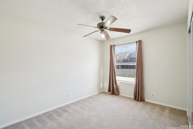 empty room featuring a textured ceiling and light colored carpet