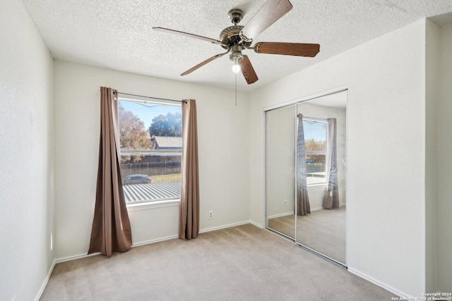 carpeted empty room featuring ceiling fan and a healthy amount of sunlight