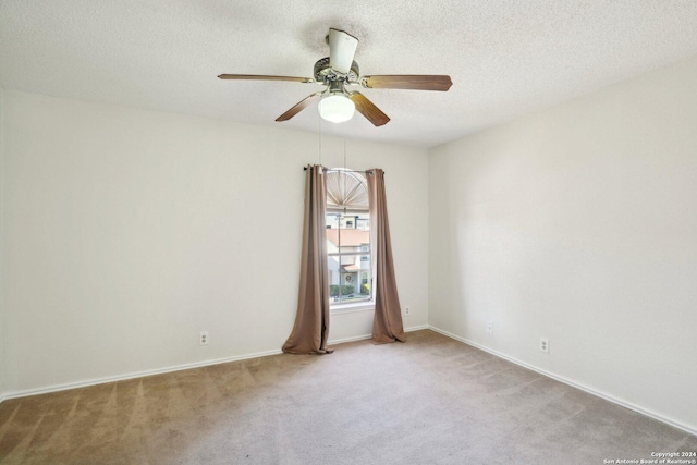 empty room with a textured ceiling, light colored carpet, and ceiling fan