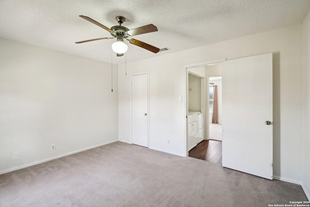 unfurnished bedroom with dark carpet, a textured ceiling, ceiling fan, washer and dryer, and a closet