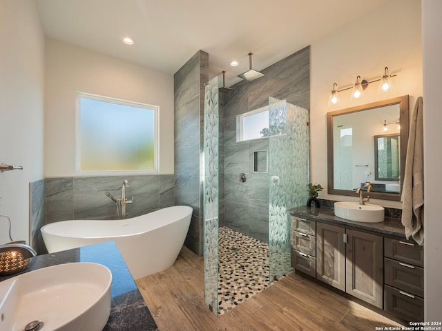 bathroom with hardwood / wood-style flooring, vanity, tile walls, and shower with separate bathtub