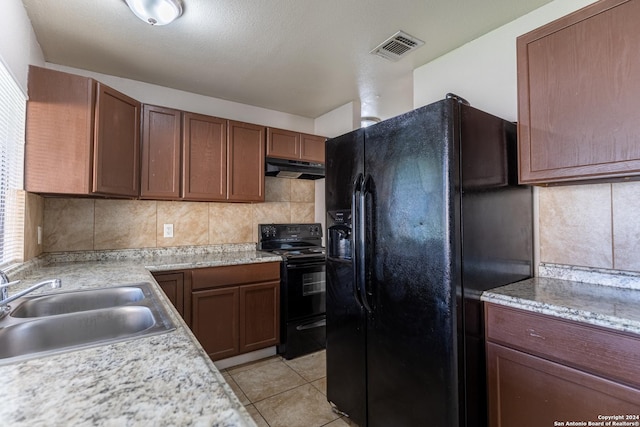 kitchen with light tile patterned flooring, decorative backsplash, sink, and black appliances