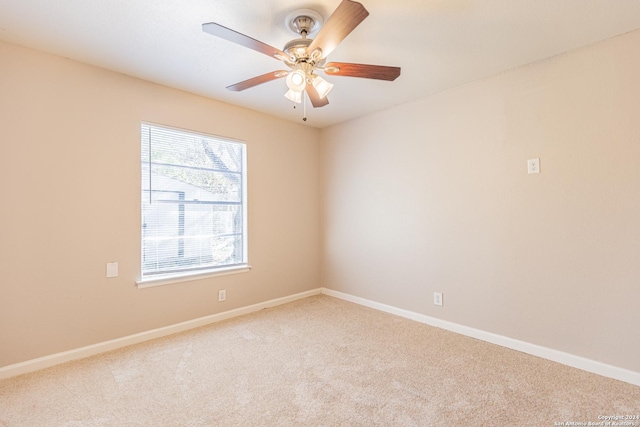 spare room featuring light carpet and ceiling fan