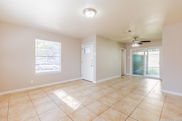 unfurnished room featuring ceiling fan, light tile patterned flooring, and a textured ceiling