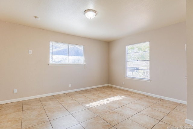 tiled empty room with a healthy amount of sunlight