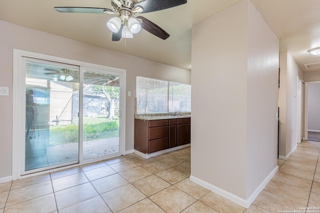 kitchen with dark brown cabinets, ceiling fan, and light tile patterned floors