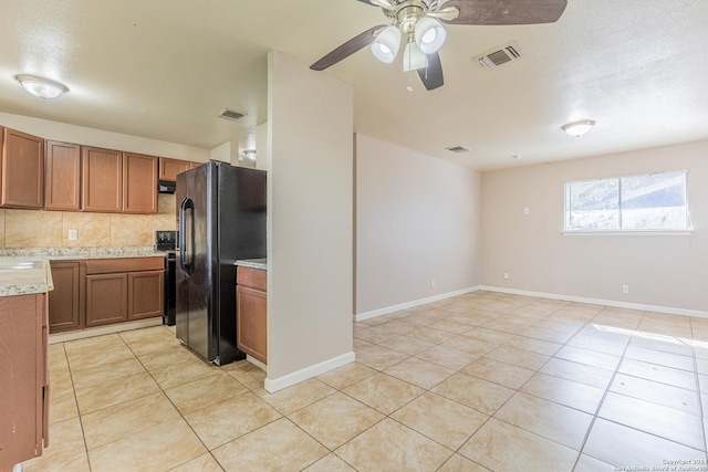 kitchen with ceiling fan, black refrigerator with ice dispenser, a textured ceiling, decorative backsplash, and light tile patterned floors